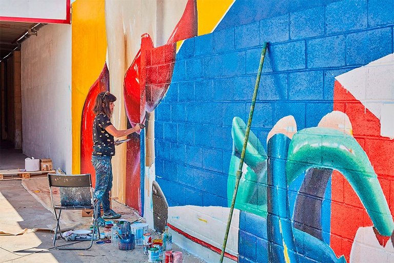 ana_barriga_pintando_mural_instalaciones_palibex_paleteria_transporte_urgente_mensajeria